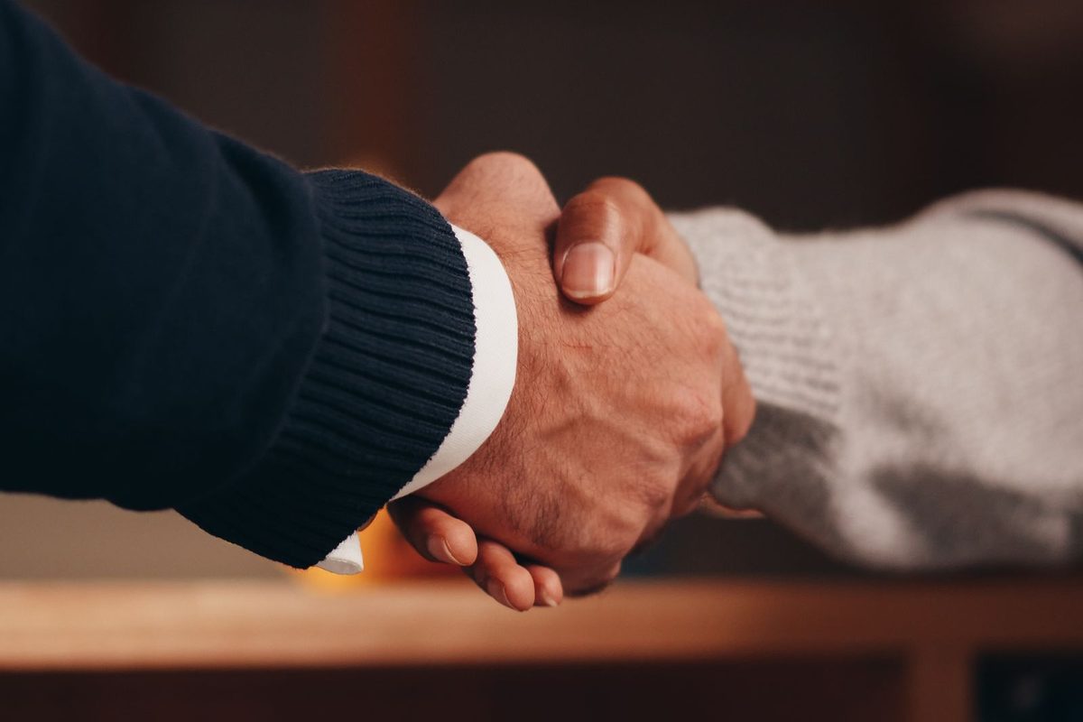 Accountant and client shaking hands over a desk after a meeting