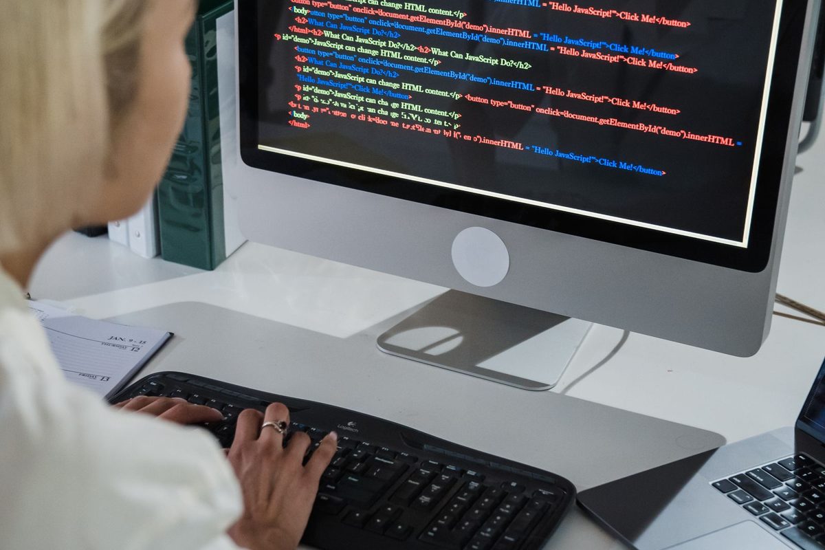 Web designer working on code at a desktop computer