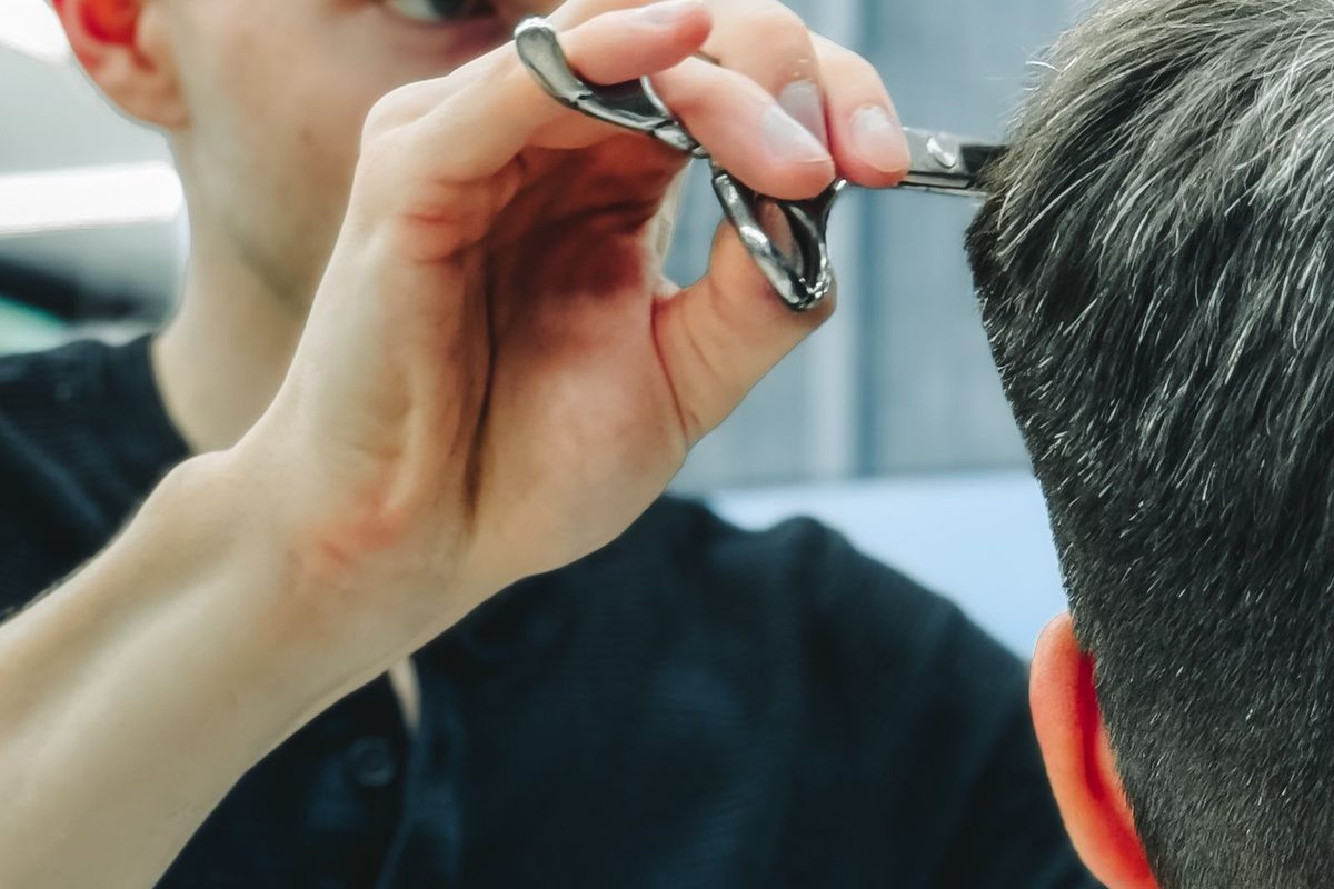 Barber cutting a client's hair with scissors