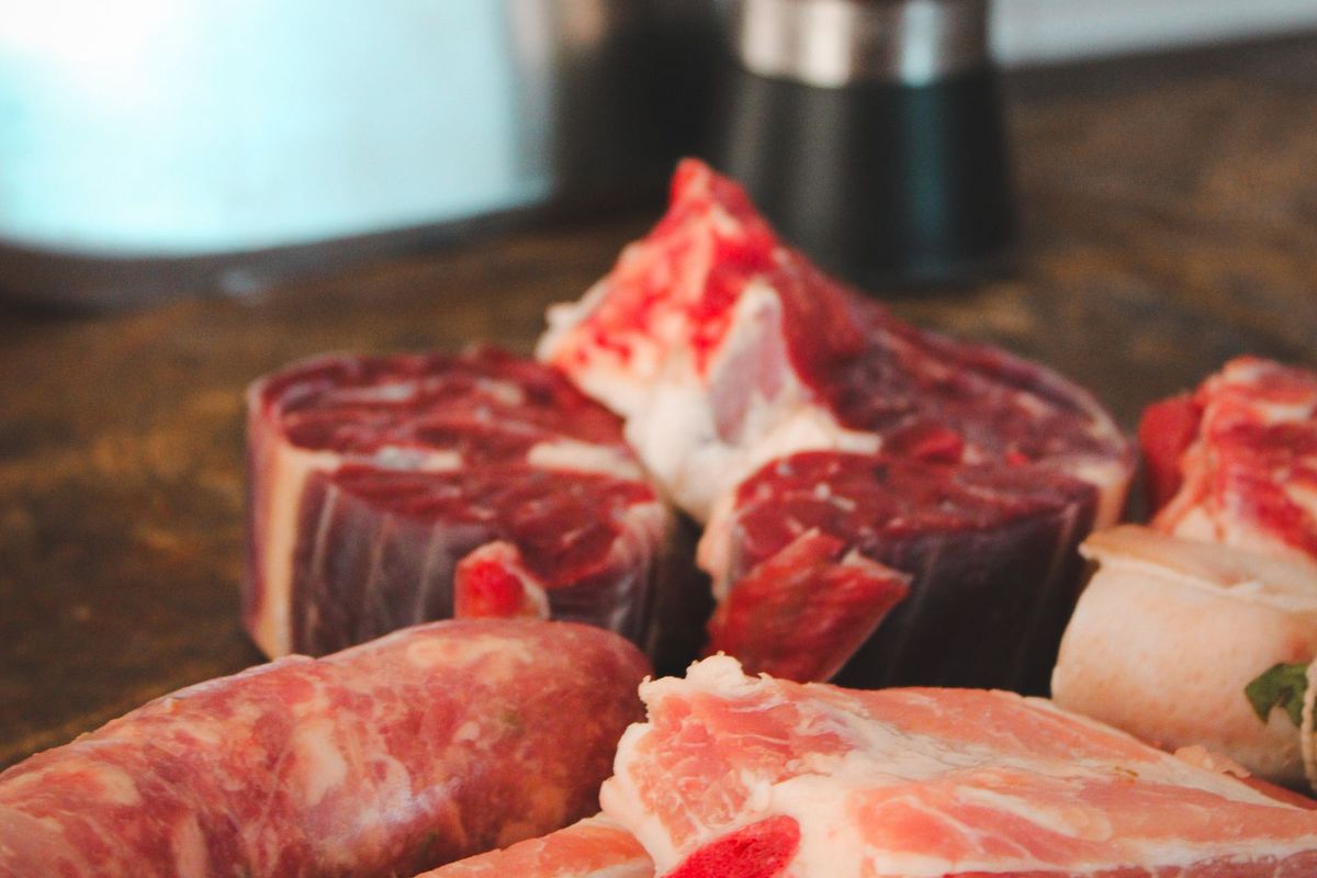 A selection of raw meat cuts on a wooden board