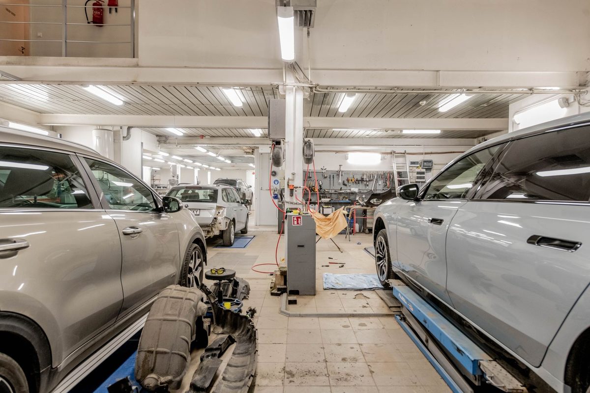 Cars on lifts in a busy car repair workshop