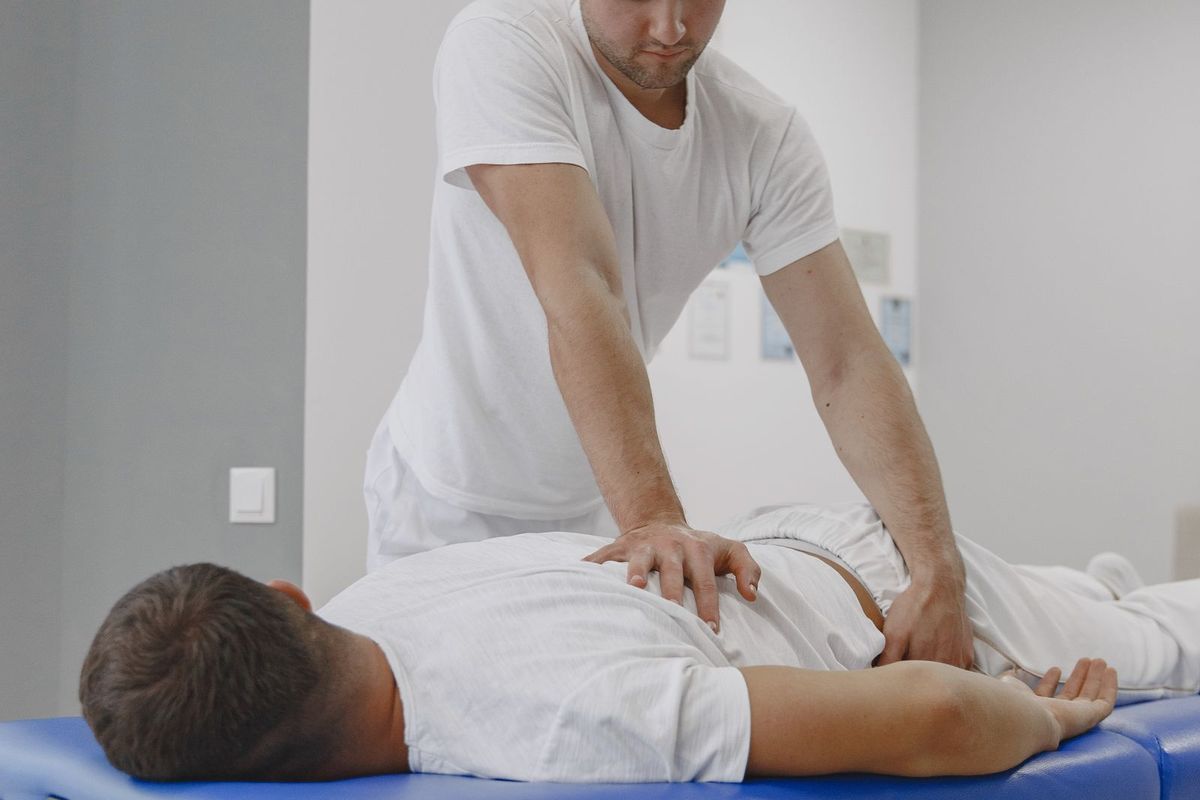 A practitioner treating a patient on a treatment table