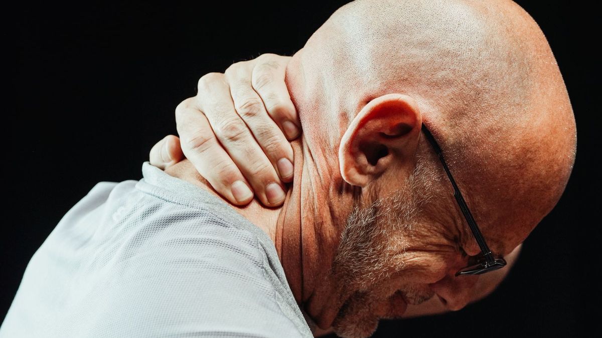 A man holding his neck in pain