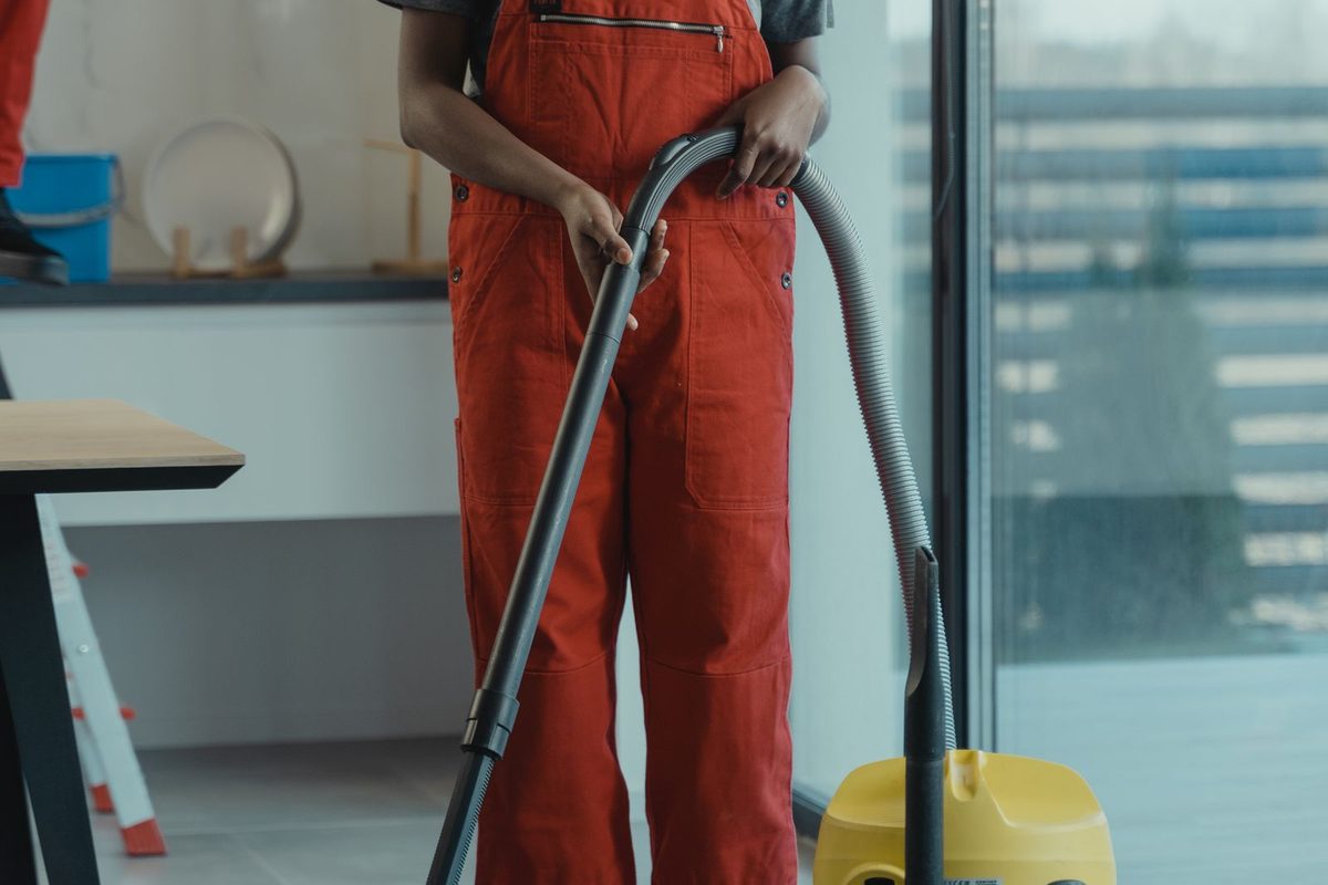 Professionale cleaner vacuuming a bright home