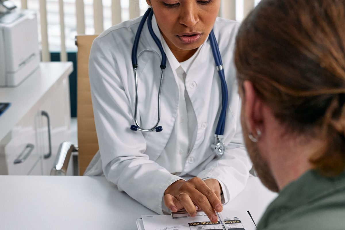 Dentist calmly explaining treatment options to a patient at a desk