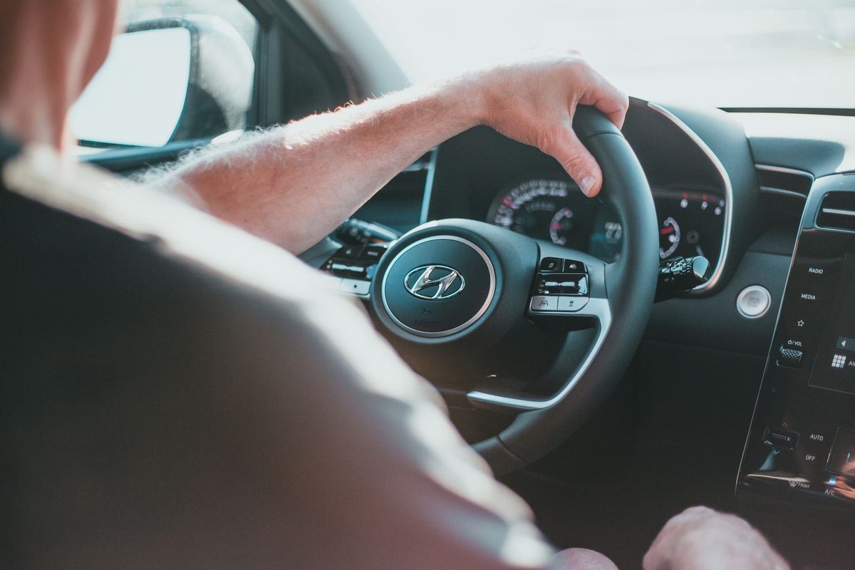 Learner driver's hands on the steering wheel of a car