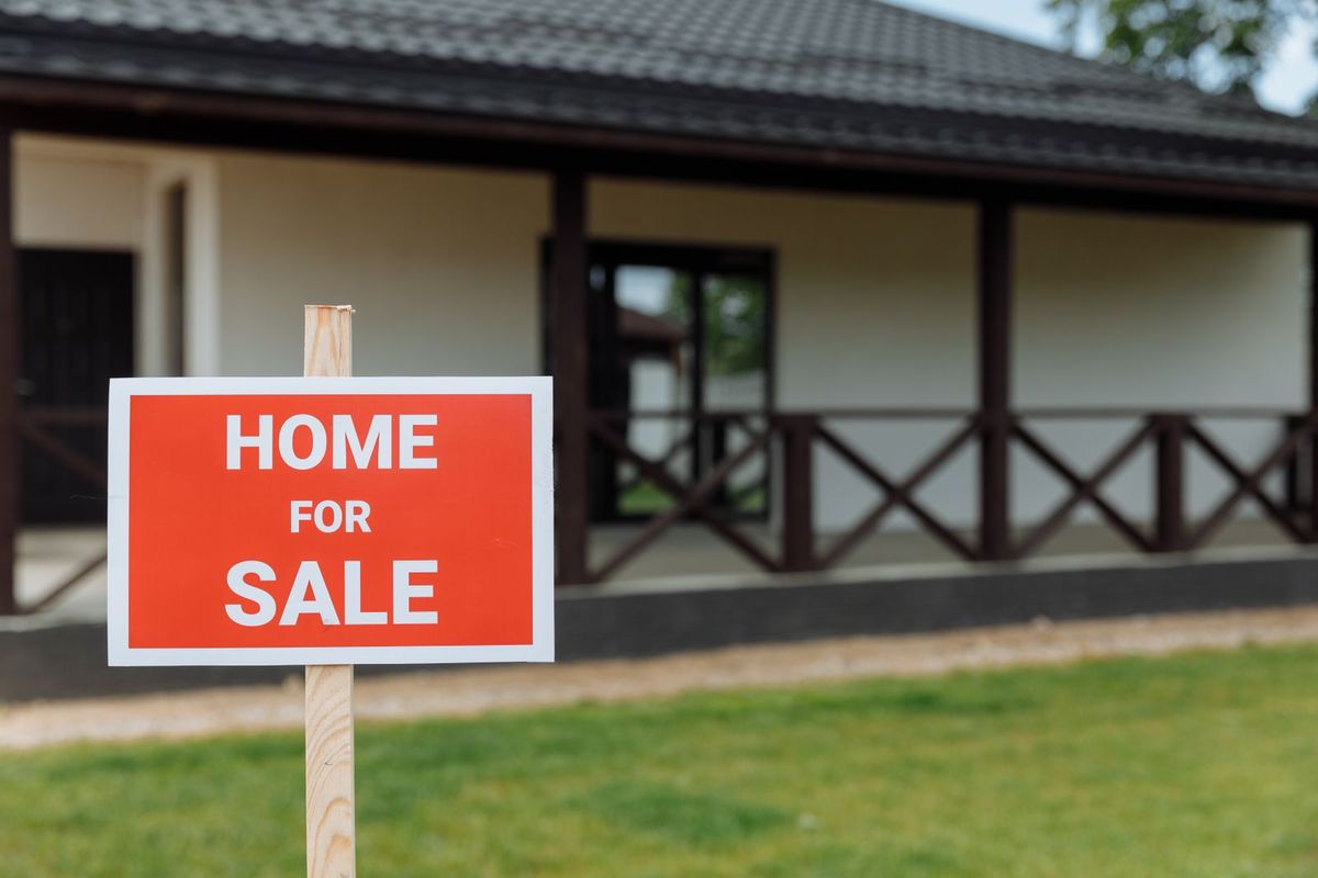 A home for sale sign outside a house
