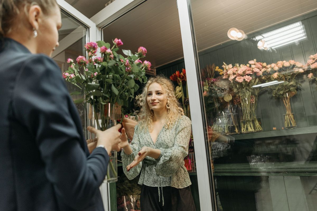 Florist arranging flowers with a customer in a flower shop