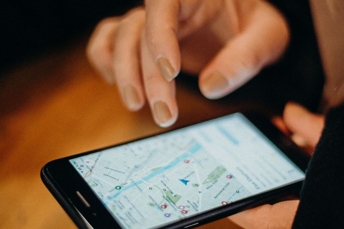 Hands using a map app on a phone at a table