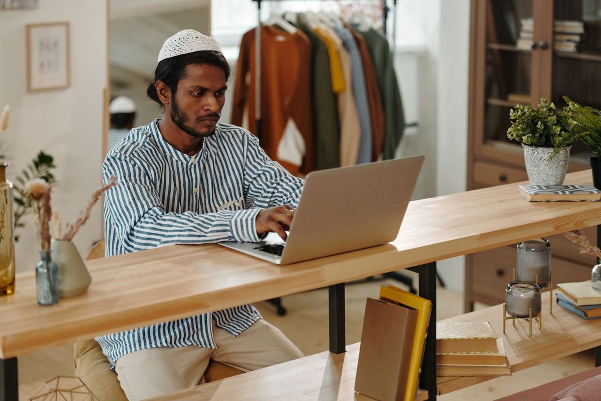 Small business owner reviewing figures on a laptop in their shop