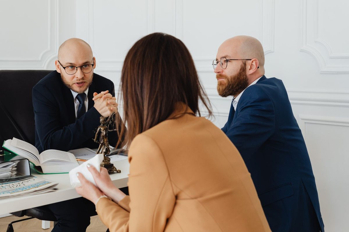 Solicitor talking with a couple across a desk in an office