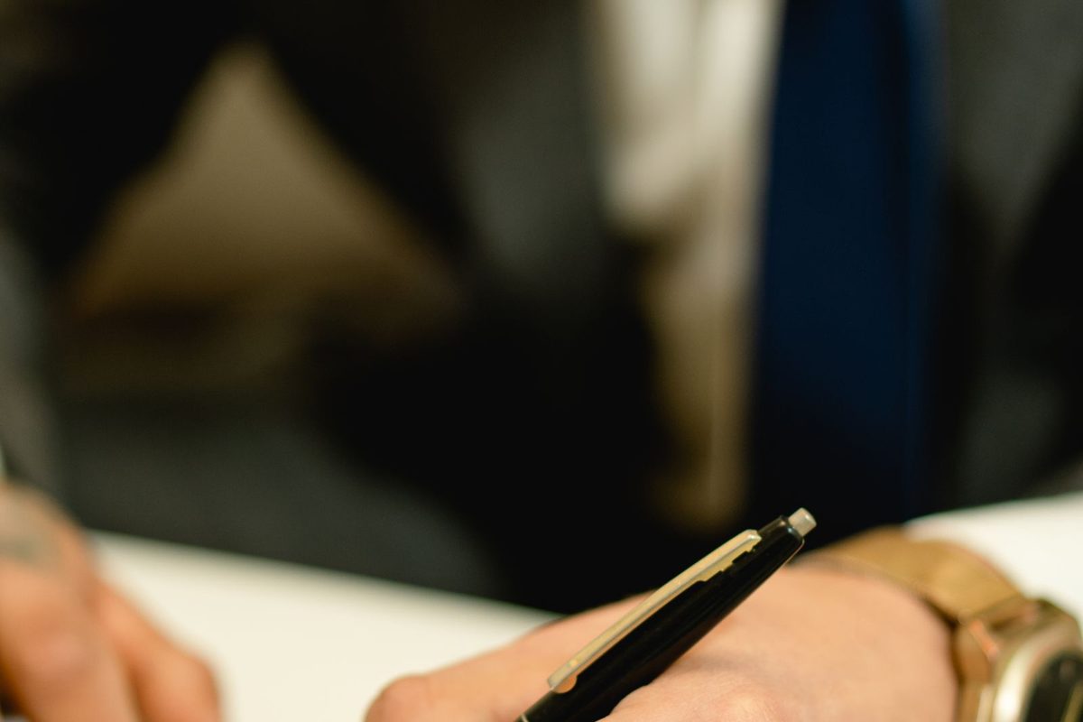 Person signing a legal document with a fountain pen