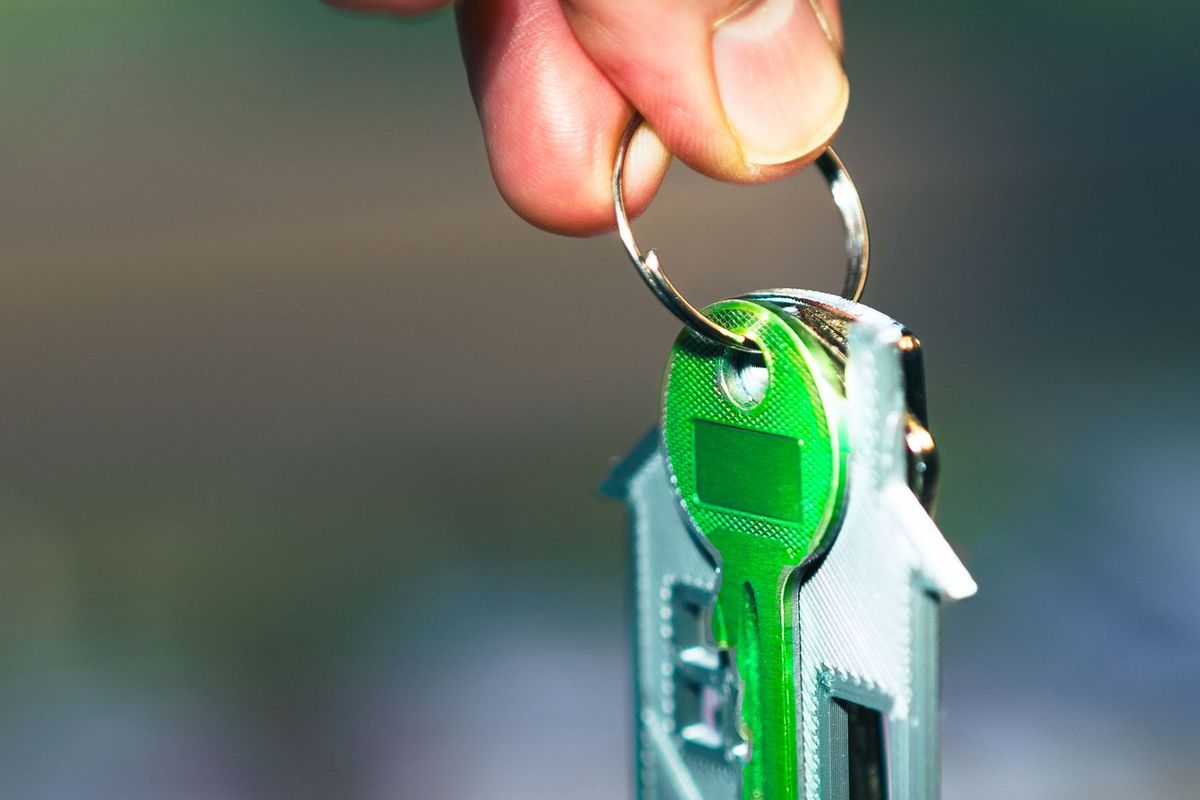 A hand holding house keys after being let back in