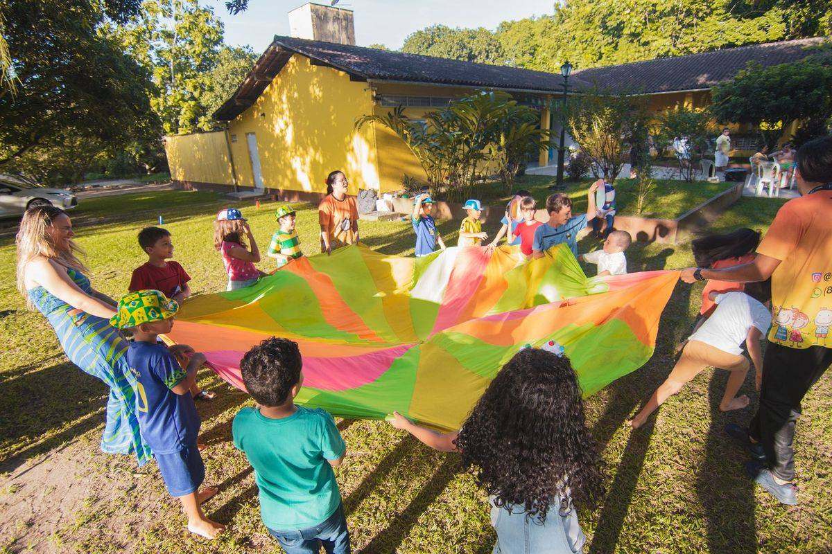 Children playing together with a colourful parachute outdoors