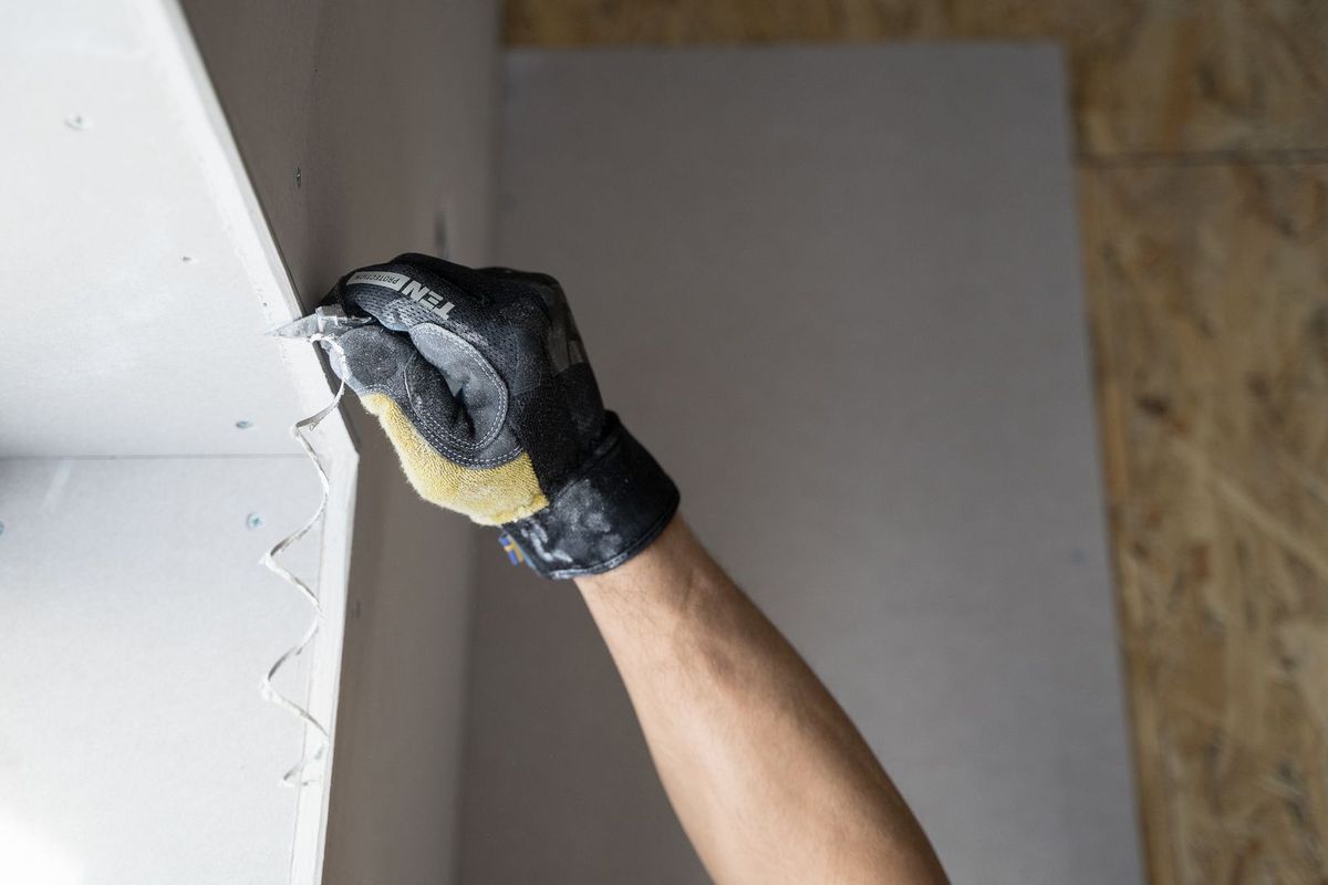 Decorator filling and sanding a wall before painting