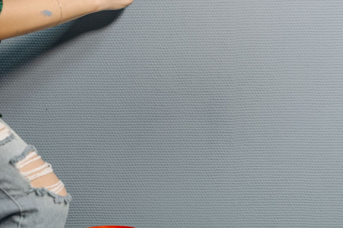Freshly painted wall with a clean edge and paint tin