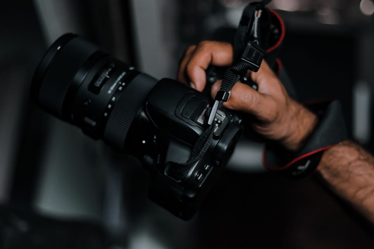 Fotografie holding a professional camera with a large lens