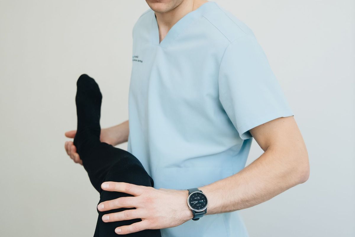 Physiotherapist treating a patient's leg during a session
