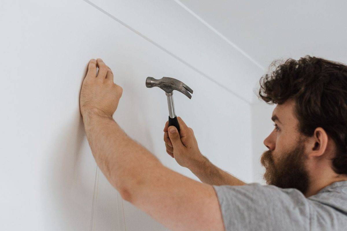 Handyman making a repair on an interior wall of a home