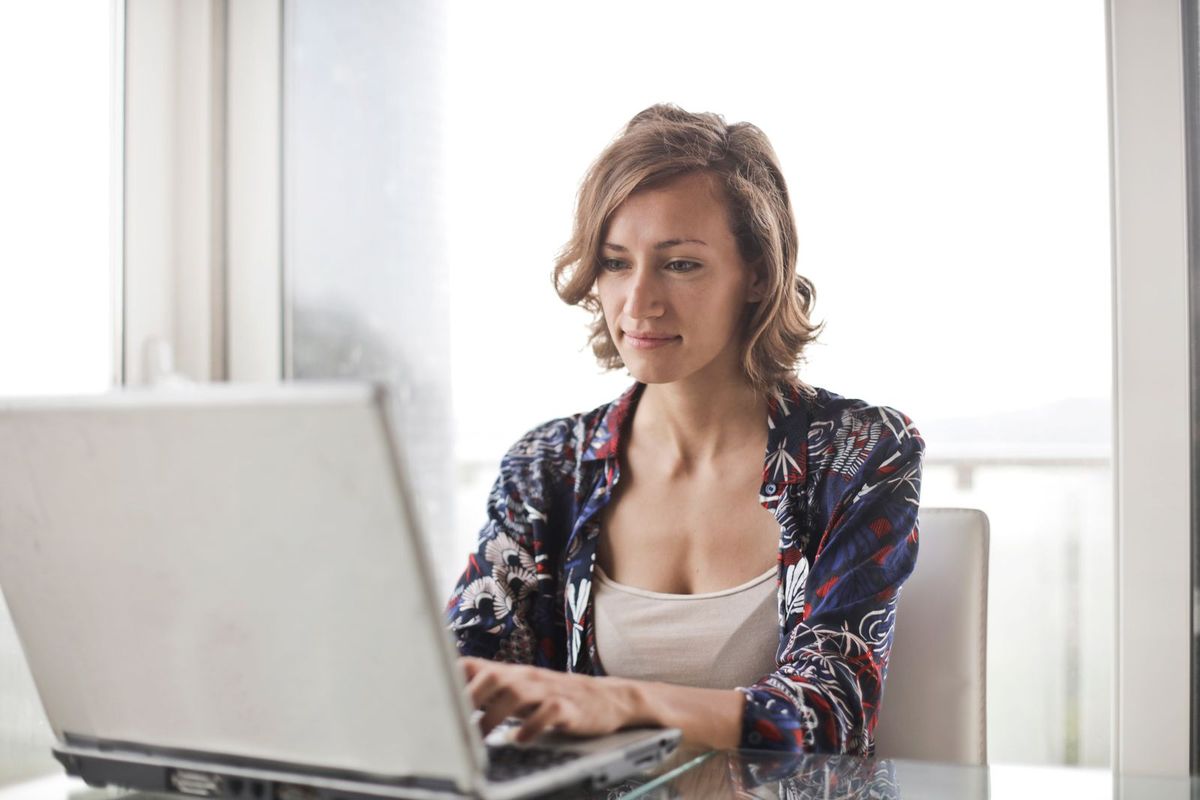 Person checking email on a laptop by a window