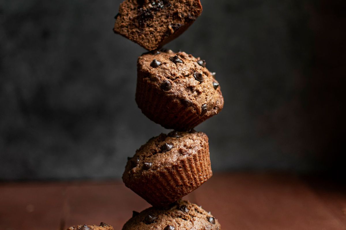 A simple, well-lit photo of stacked muffins on a dark surface
