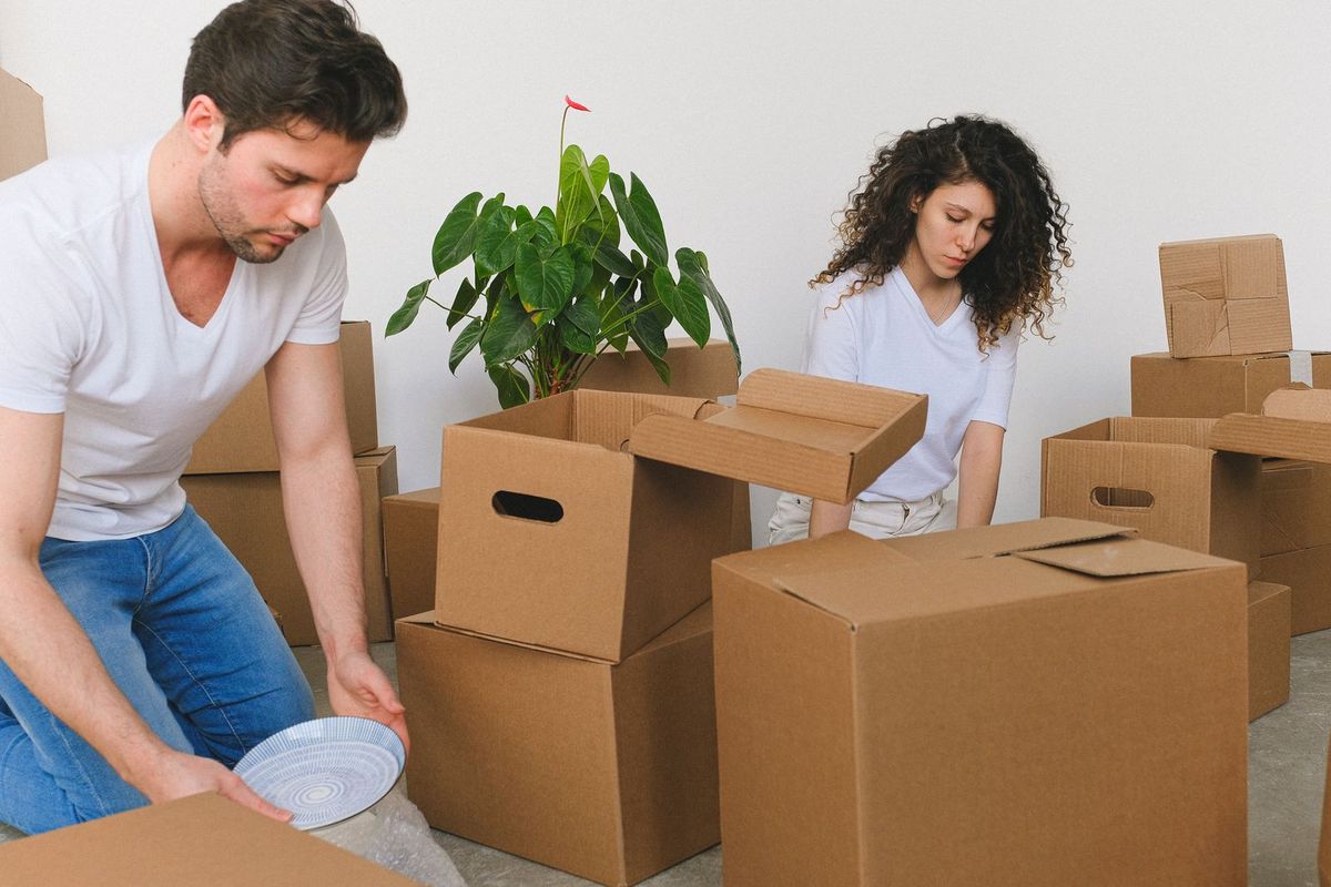 Movers carefully wrapping and packing belongings