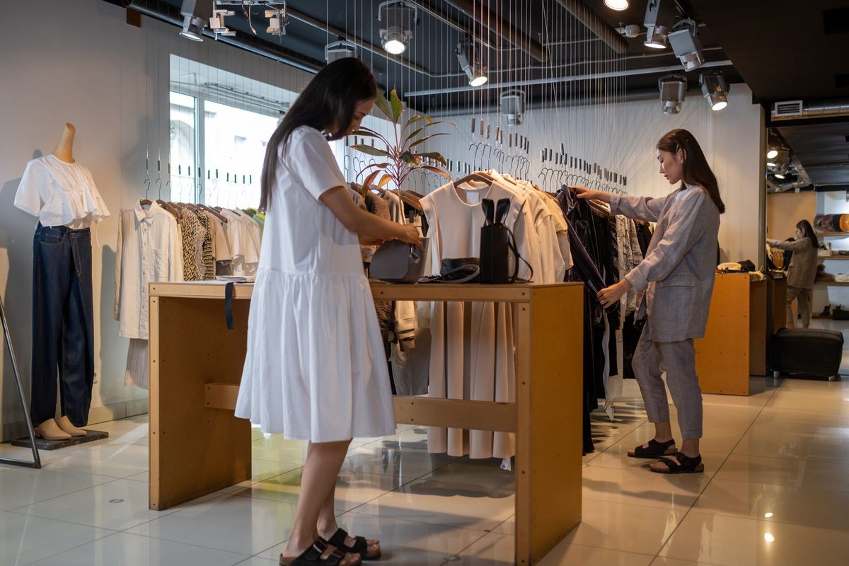 Personalizadoer browsing clothes with a shop assistant in a boutique