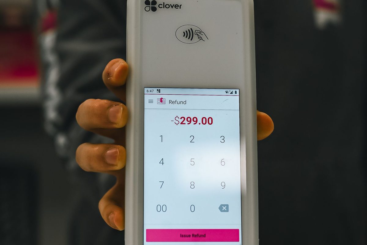 Personalizadoer paying by contactless card at a shop counter