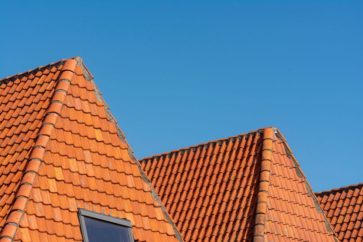 Neatly finished tiled roof against a blue sky