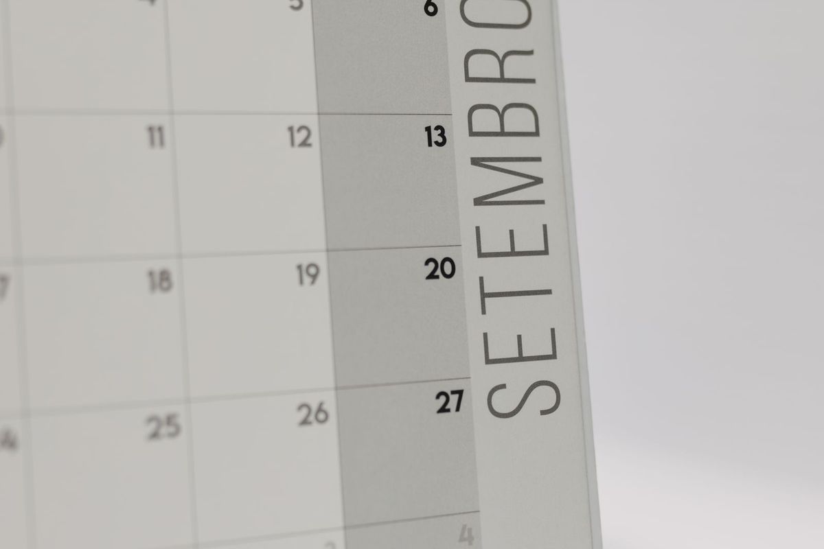 A monthly desk calendar on a work surface