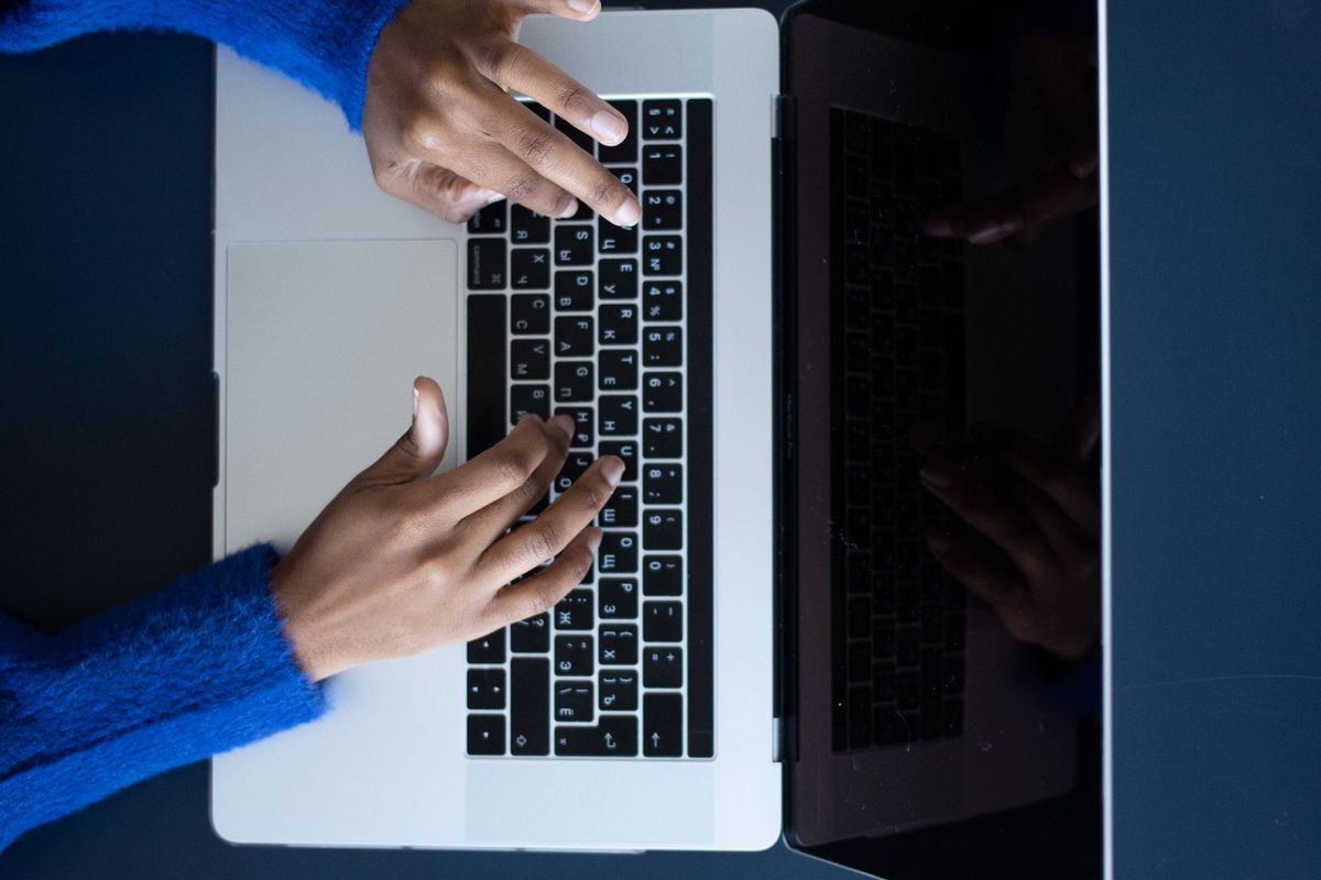 Person writing a blog post on a laptop
