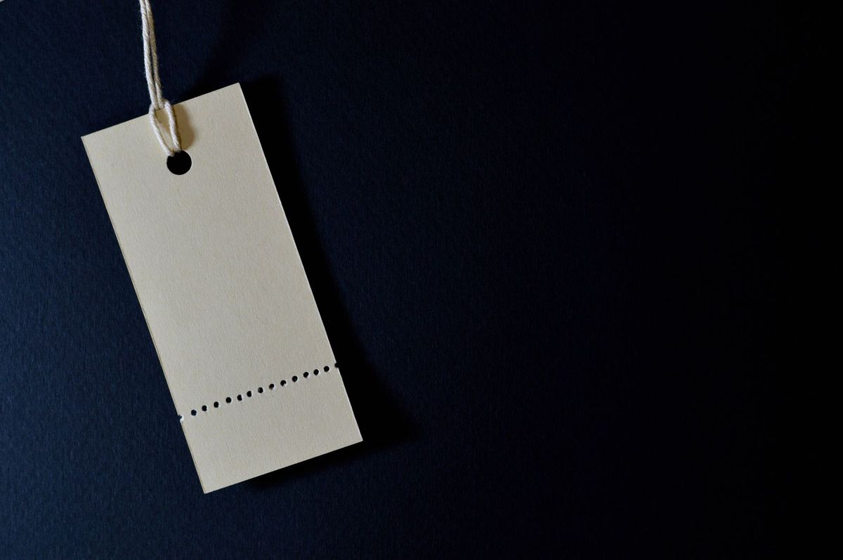 A blank price tag on a dark surface