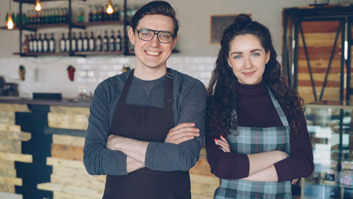 Two small business owners standing proudly in their shop