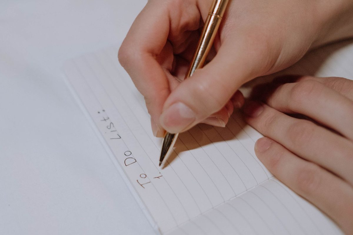 Hand writing a checklist with a pen in a notebook