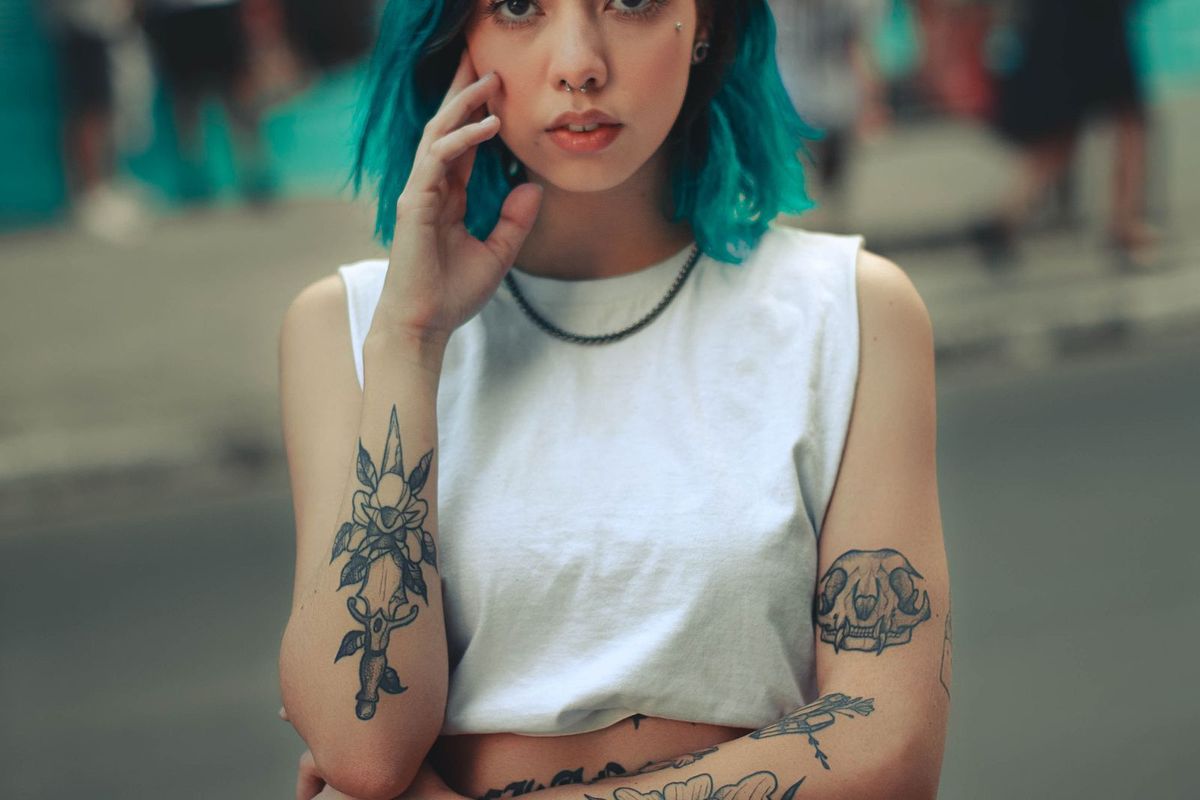 A person with visible tattoos on their arms