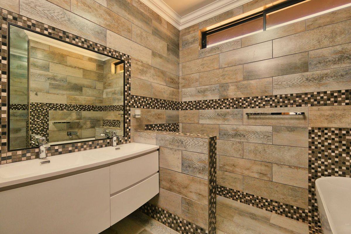 A beautifully tiled bathroom with a feature mosaic border