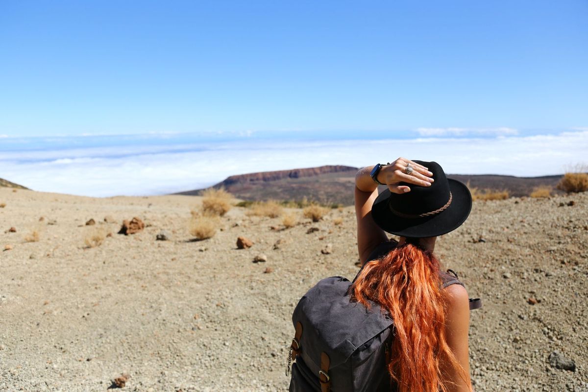 A traveller with a backpack looking out over a landscape