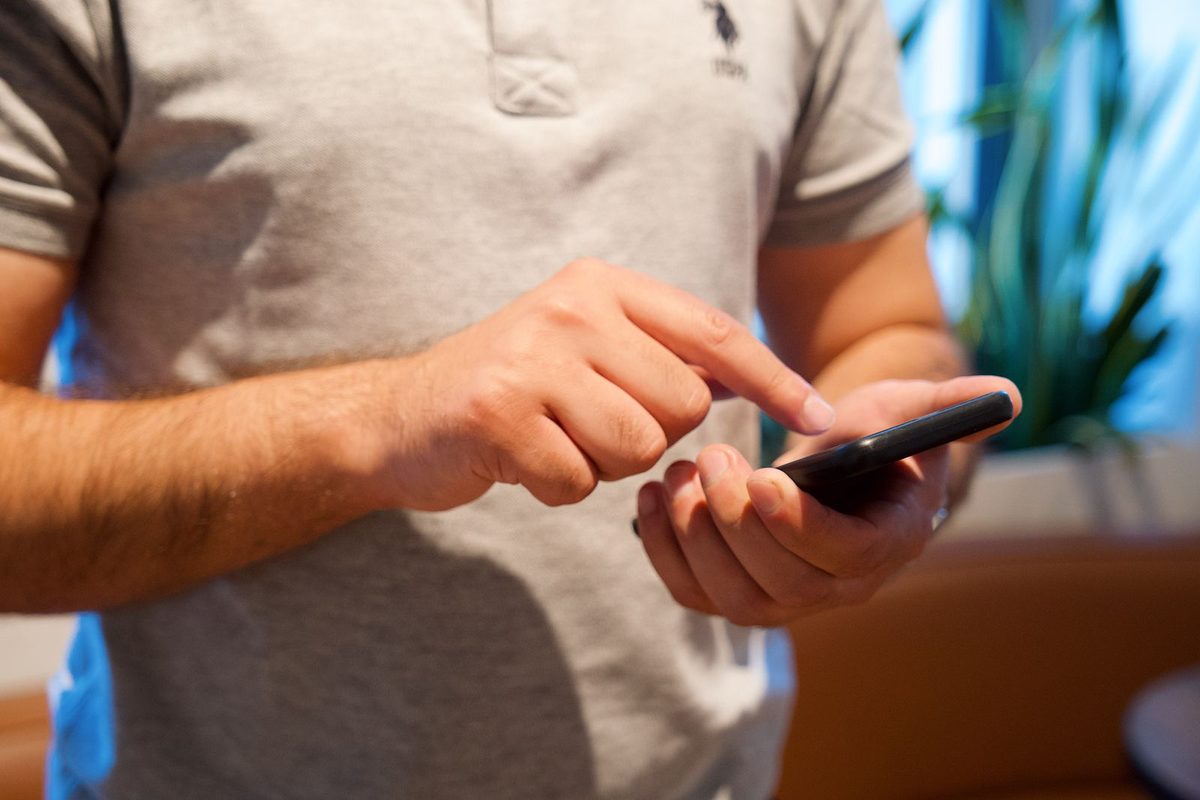 Person tapping on a smartphone in a small business
