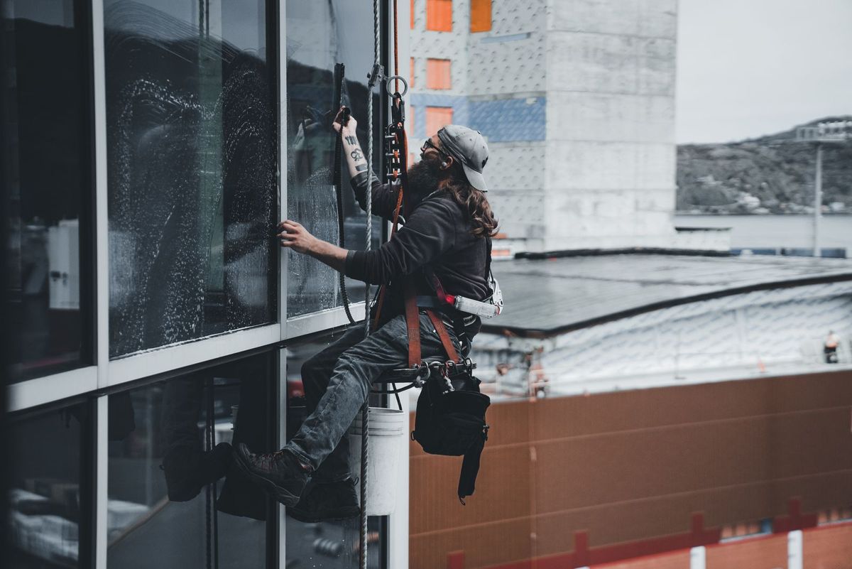 A professional window cleaner at work on a building