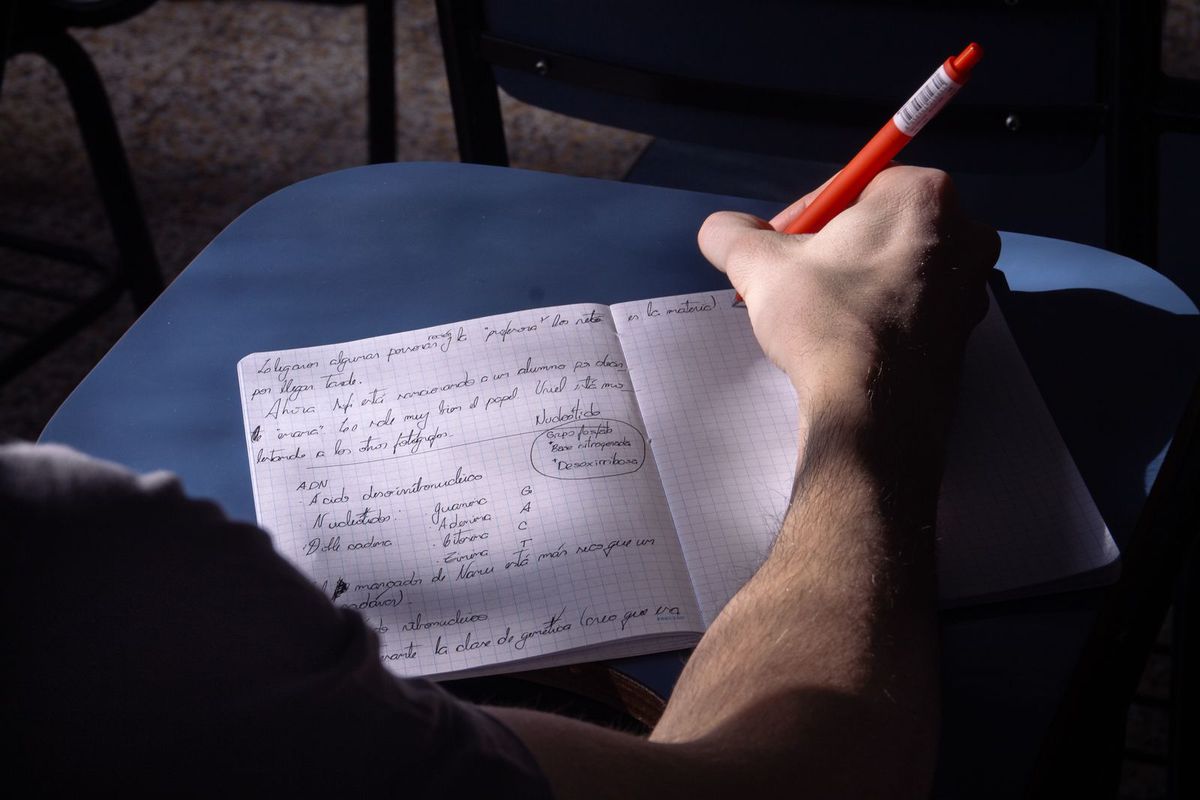 Hand drafting an article outline in a notebook